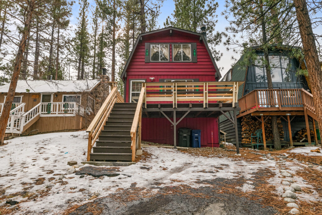 A red house with stairs leading to the top of it.