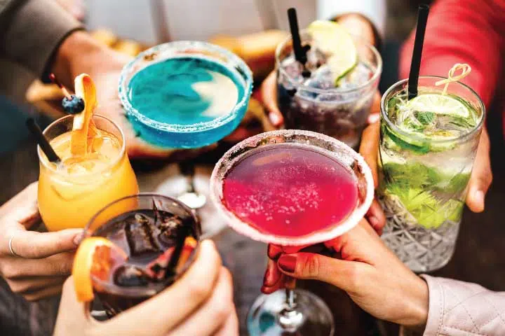 A group of people holding drinks at a table.