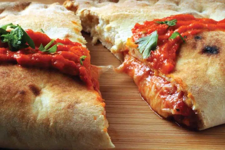 A close up of some pizza on a wooden board