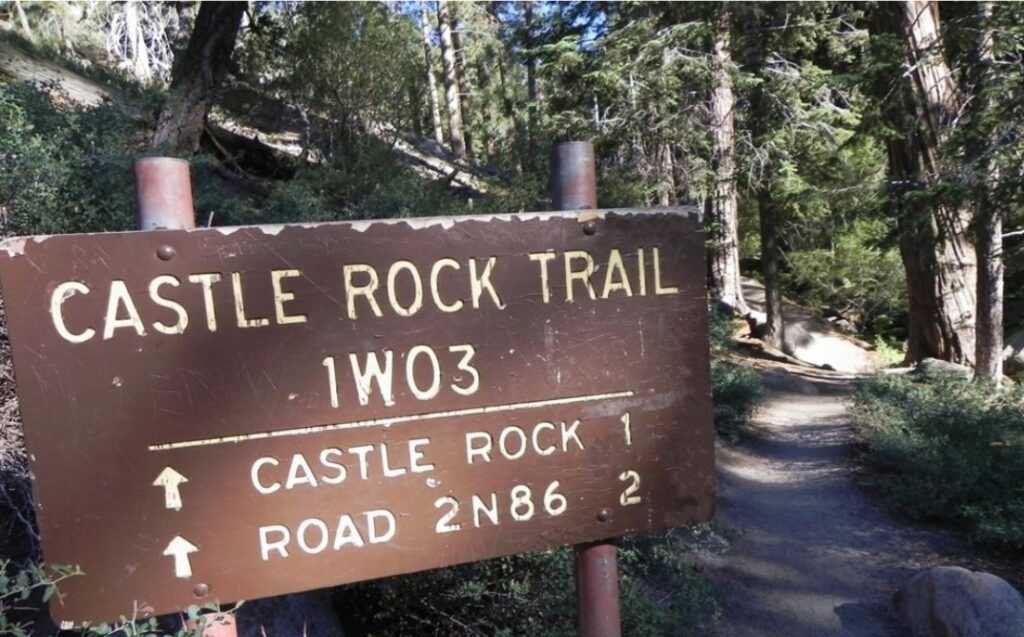 A sign on the side of a road that says castle rock trail.