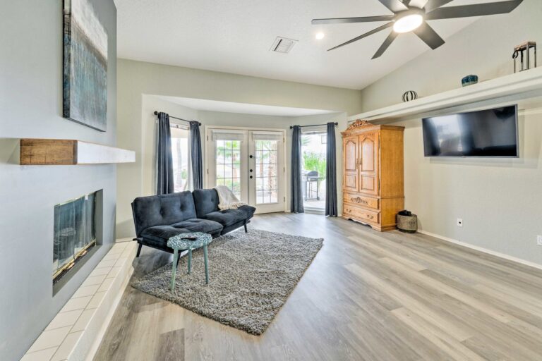 A living room with a couch, chair and television.