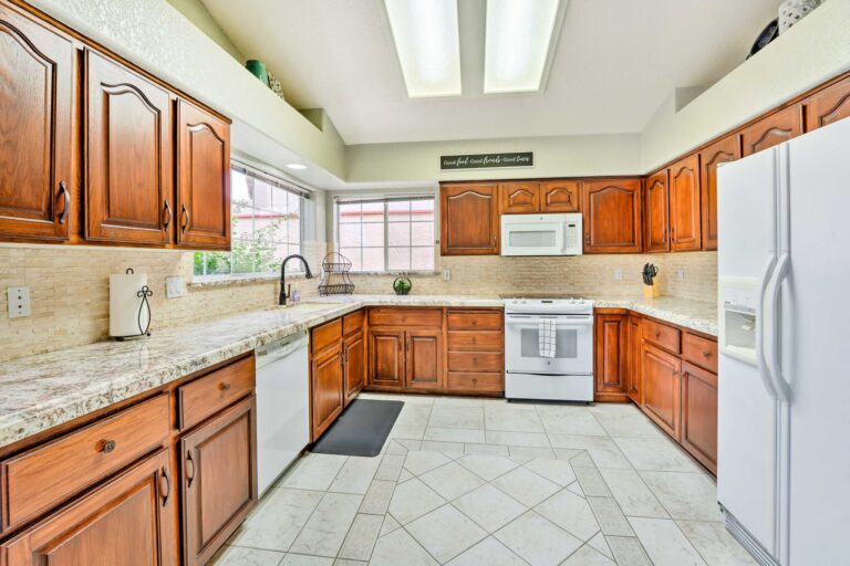 A kitchen with wooden cabinets and white appliances.