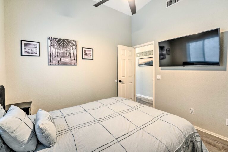 A bedroom with a bed, tv and window.