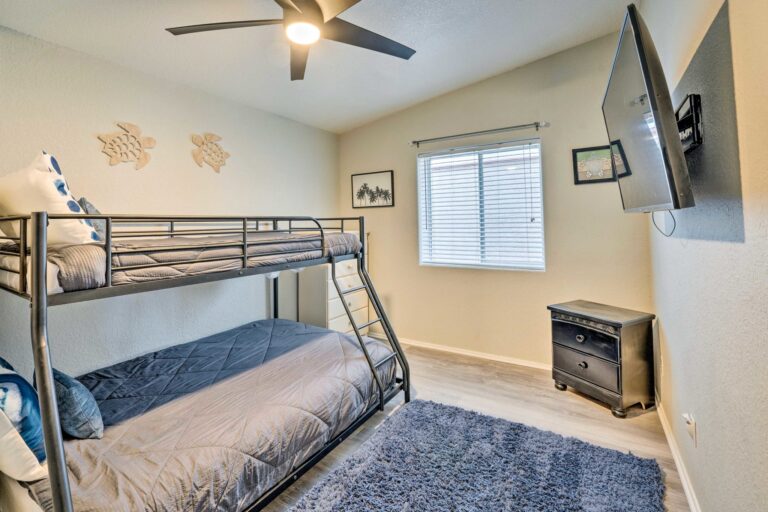 A bedroom with two bunk beds and a ceiling fan.